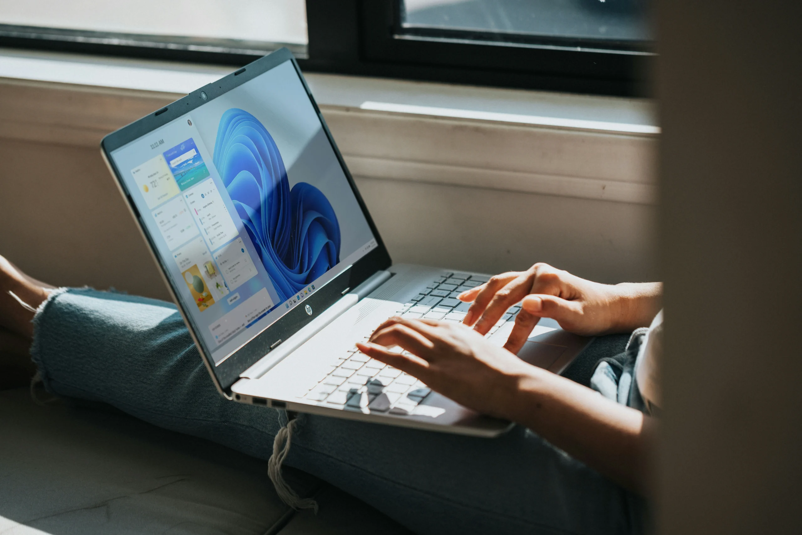 Windows 11 コンピューターで作業している人。(画像ソース: Windows、Unsplash)