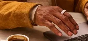 Oura Ringを装着した手でノートパソコンを操作している公式ライフスタイル画像